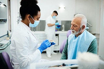 An older man talking to his dentist about dentures