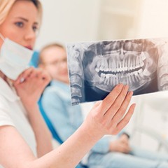 Dental hygienist shows patient dental X-rays