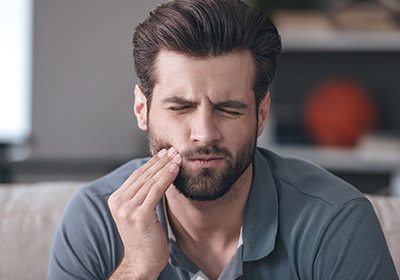 Man holding jaw in pain