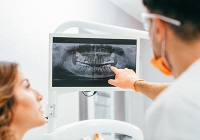 Dentist and patient looking at digital x-rays