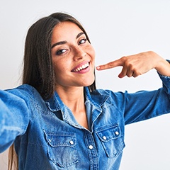 Woman taking a selfie while pointing to her smile