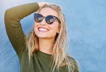 blonde woman wearing sunglasses and smiling