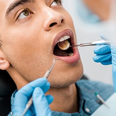 Dentist examining man’s mouth
