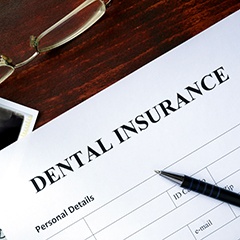 Top of dental insurance form with pen and glasses