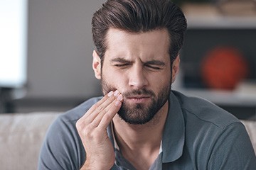 Man holding cheek  in pain