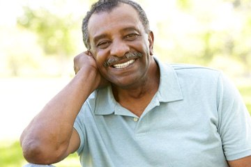 Patient in Naples smiling with their new implant dentures