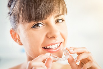 Woman holding her Invisalign tray