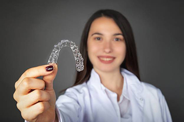 Woman holding clear aligner
