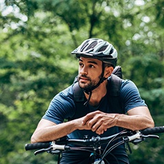 Man with helmet on bike outside