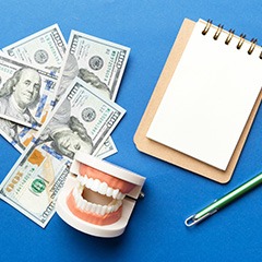Money and notepad with pen and mouth mold