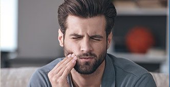 Man holding jaw in pain