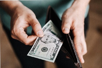 Man looking at cash in wallet