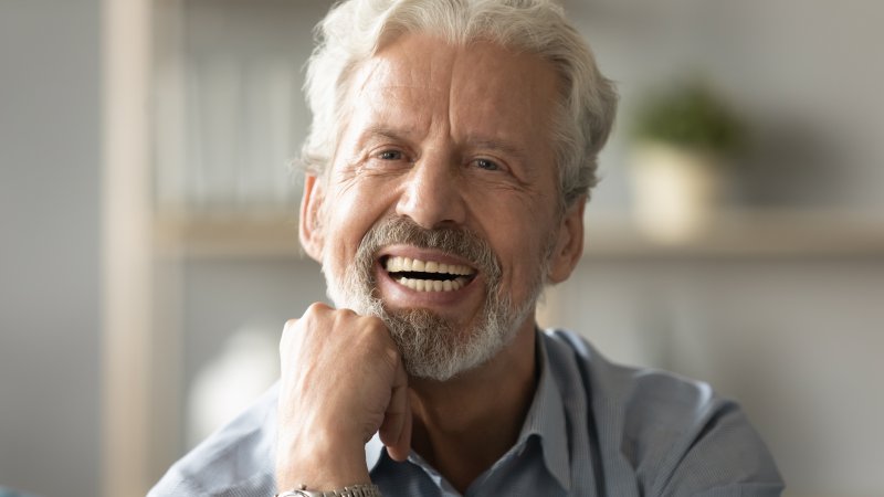 An older man smiling with his dentures