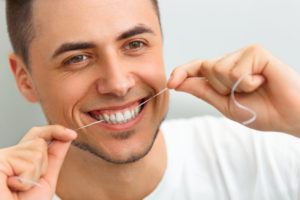 young man smiling while flossing
