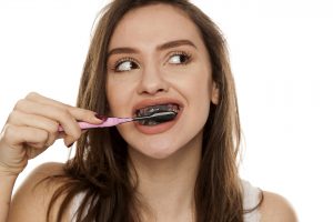 Woman trying teeth whitening with charcoal