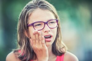 young girl holding face in pain