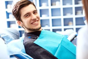 young man in dentist chair smiling