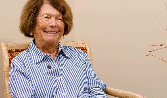 Smiling older woman in a striped blouse in a patient video testimonial