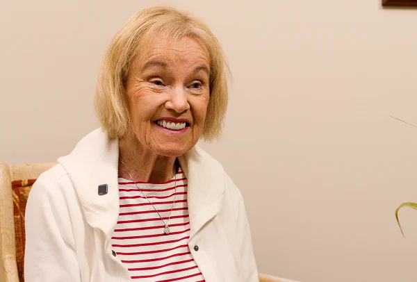 Smiling older woman with short blonde hair in a red striped top