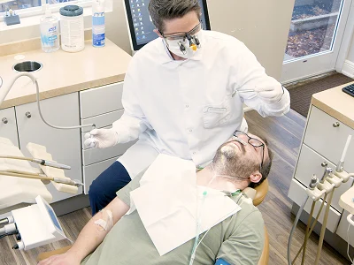 Dentist treating a relaxed patient in the treatment room